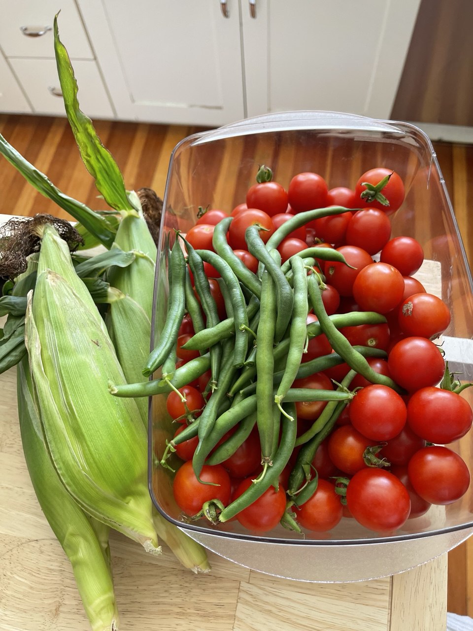 Summer harvest of corn, green beans, and cherry tomatoes